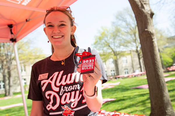 A student worker handing out gift "mule shoes".