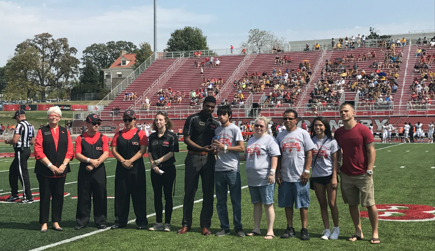 2018 Family of the Year on the football field with the Provost and USHA president.