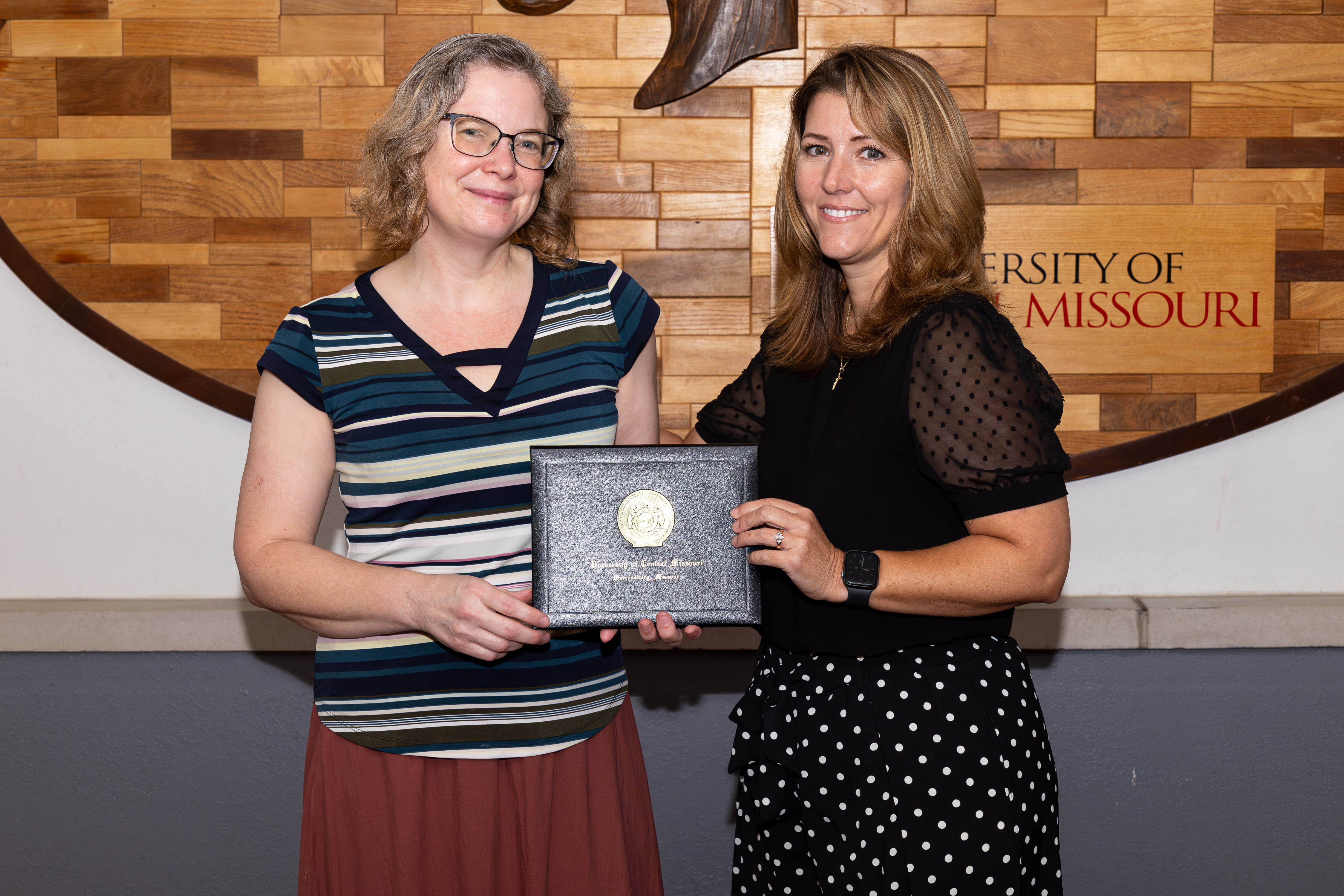 Kathy Strickland holding award with Kelly Cramer.