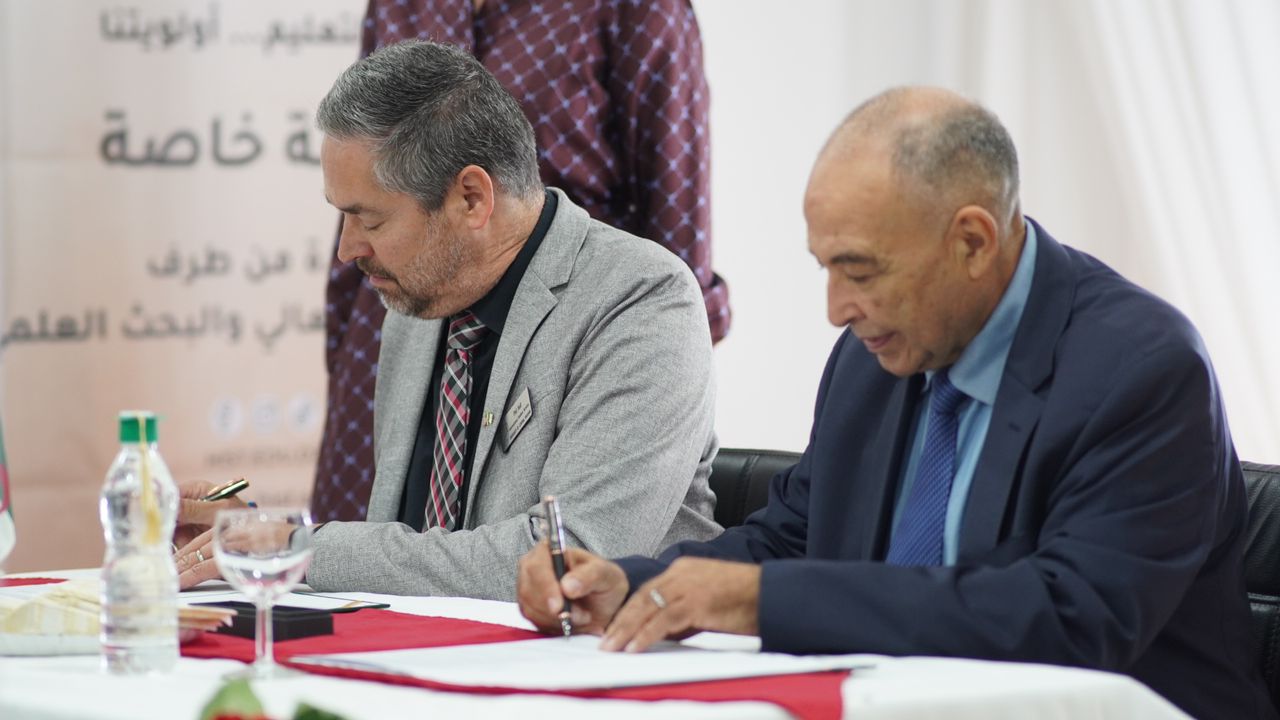 Dr. Hull and Dr. Mazouz signing agreement.