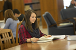 female student studying at desk in library