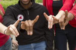 students showing "snouts out" hand symbol