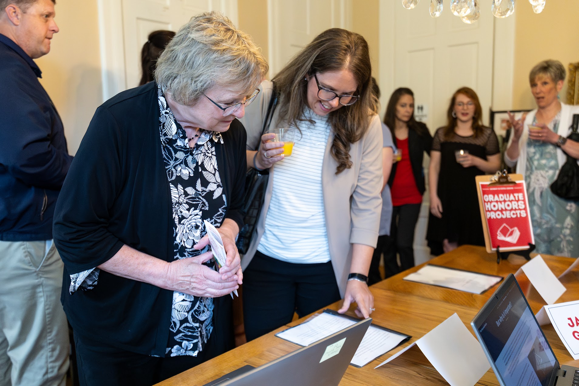 Ann McCoy with Honors Projects. Dr. Ann McCoy viewing Honors Projects.